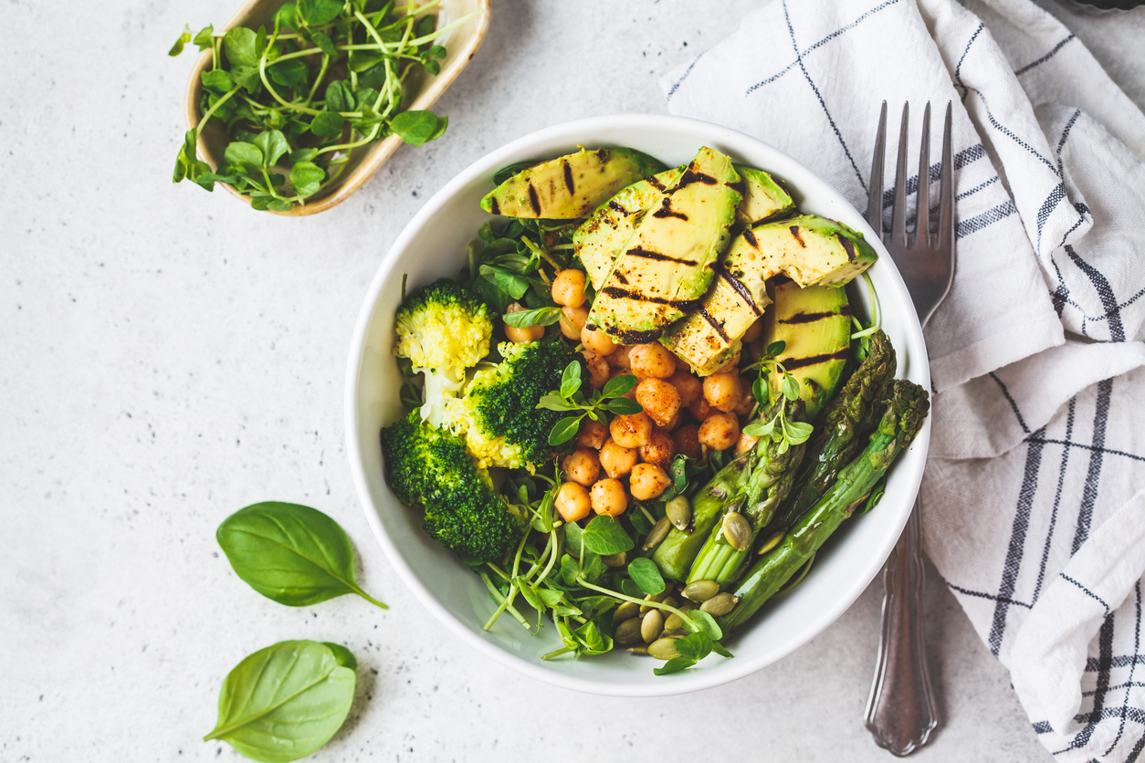 Buddha bowl with grilled avocado, asparagus, chickpeas, pea sprouts and broccoli.